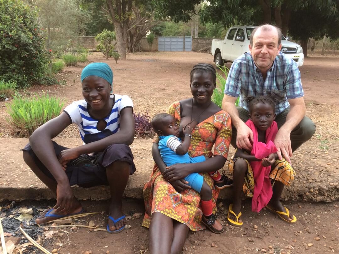 Una donna con il suo bambino, una ragazza, una bambina e un uomo seduti all'aperto in Chad